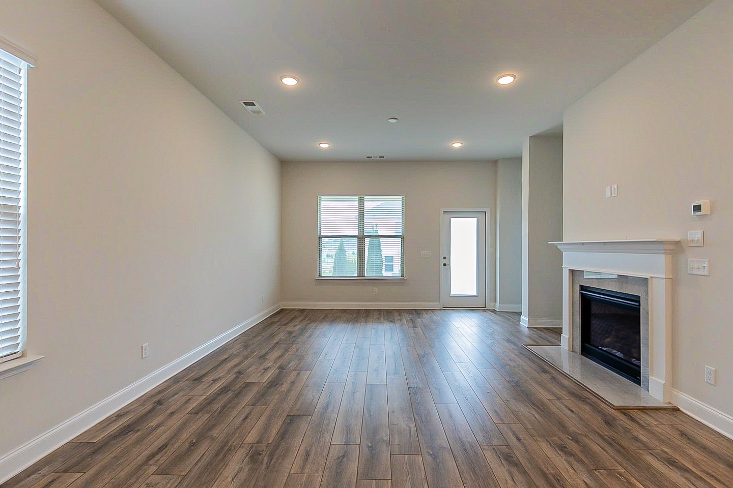 1001 Lonergan Circle Spring Hill, TN 37174 - Photo 10 of 38 an empty room with wooden floor fireplace and windows