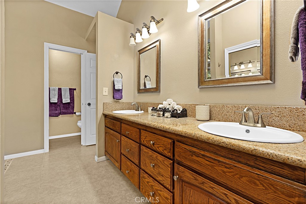 1011 Farrand Court Fallbrook, CA 92028 - Photo 10 of 49 a bathroom with a granite countertop double vanity sink and a mirror