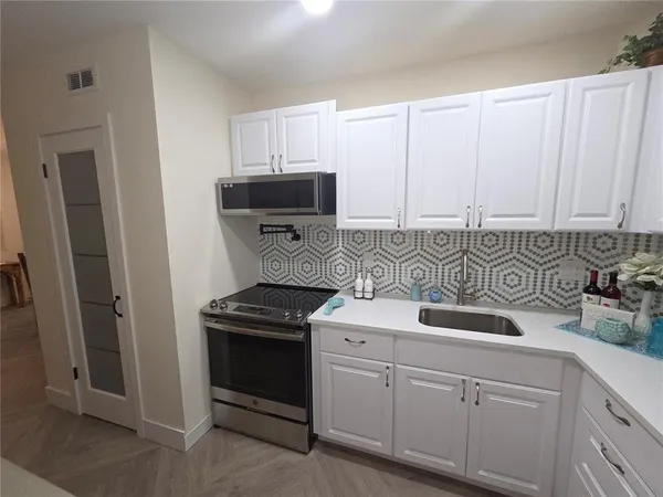 a kitchen with stainless steel appliances a stove sink and cabinets