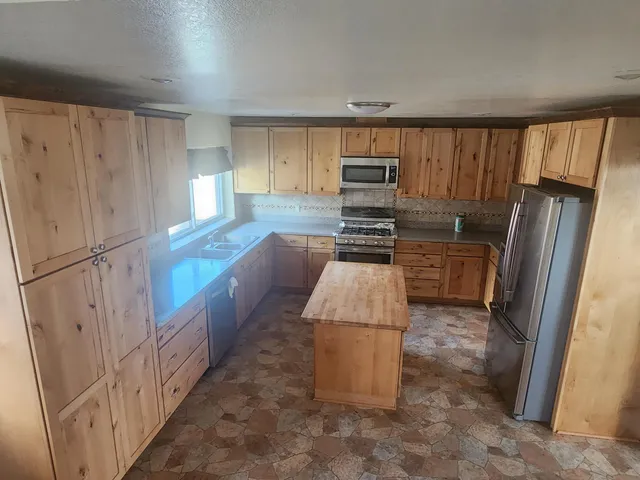 a kitchen with stainless steel appliances a refrigerator and wooden cabinets