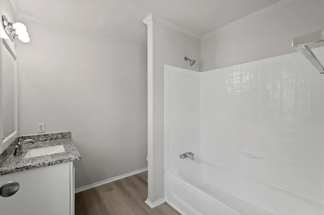 a bathroom with a granite countertop sink and a bathtub