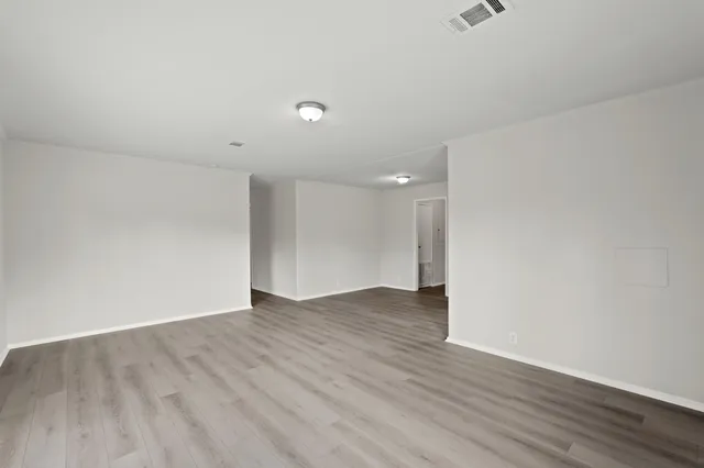 a view of an empty room with wooden floor