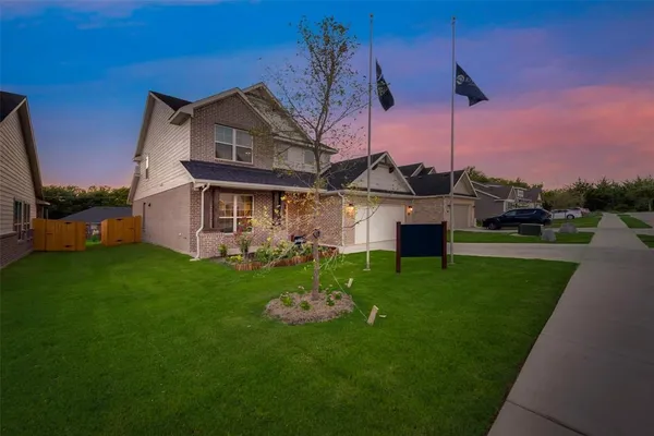 a front view of a house with a garden and yard