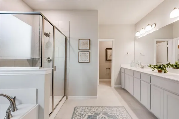 a bathroom with a double vanity sink mirror and shower