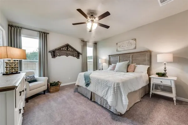 a spacious bedroom with a bed and a ceiling fan