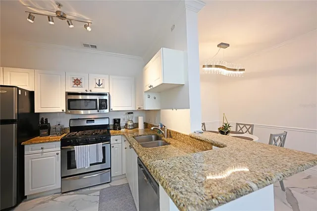 a kitchen with stainless steel appliances kitchen island granite countertop a refrigerator and microwave