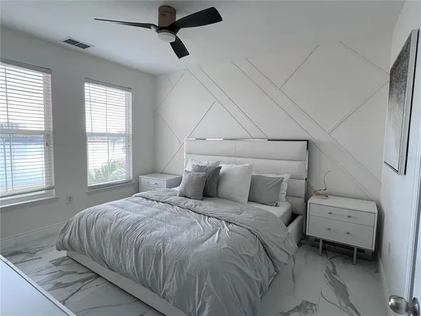 a large bed sitting in a bedroom next to a window