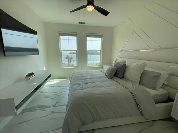 a bedroom with a bed and wooden floor