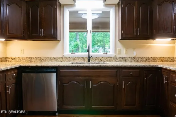 a kitchen with granite countertop cabinets sink and window