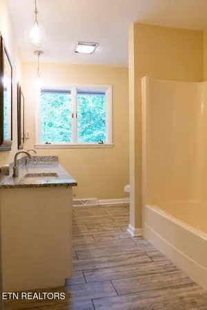a bathroom with a granite countertop sink and a mirror