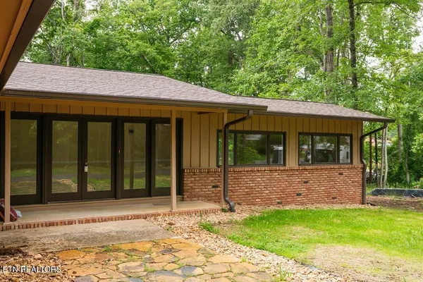 a backyard of a house with barbeque oven table and chairs