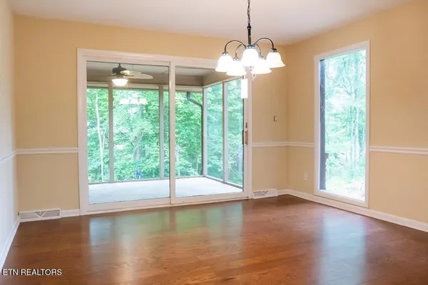a view of a room with wooden floor and a floor to ceiling window