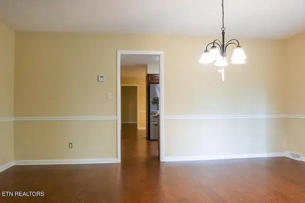 a view of a room with wooden floor and white walls