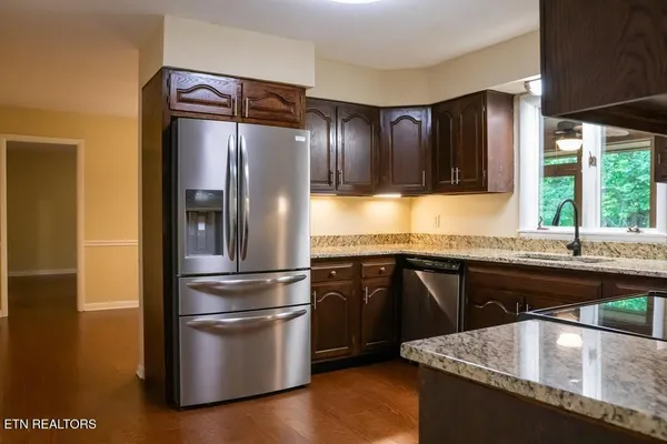 a kitchen with granite countertop a refrigerator and a sink