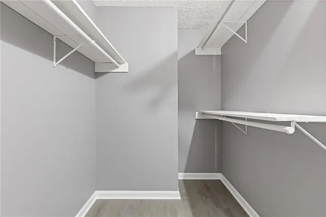 a view of walk in closet with empty racks
