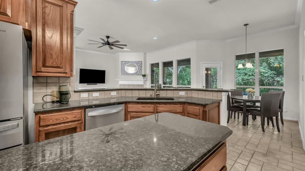 203 Mockingbird Lane Aledo, TX 76008 - Photo 20 of 37 Kitchen featuring wood cabinetry, dark stone countertops, stainless steel appliances, and a tiled backsplash