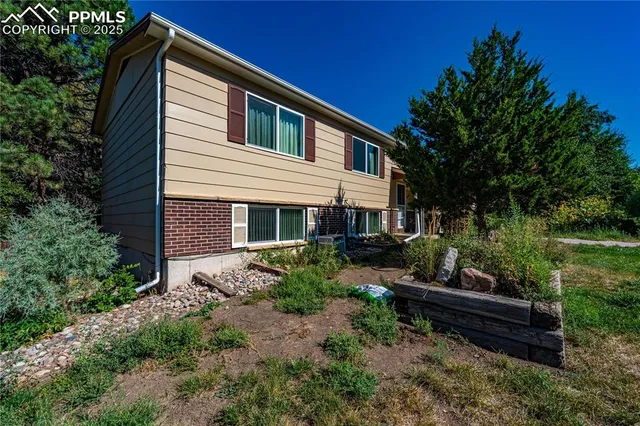 a view of a house with backyard and sitting area