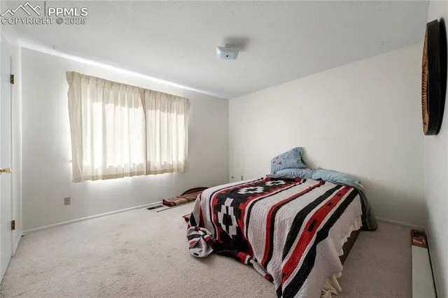 a bed sitting in a bedroom next to a window