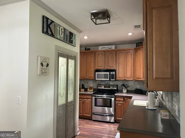 a kitchen with a refrigerator and a stove top oven