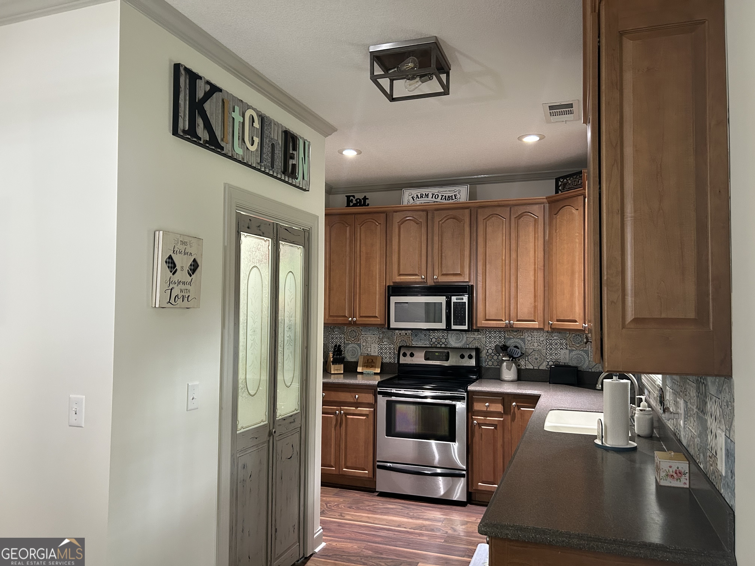 94 24th Avenue Eastman, GA 31023 - Photo 14 of 27 a kitchen with a refrigerator and a stove top oven