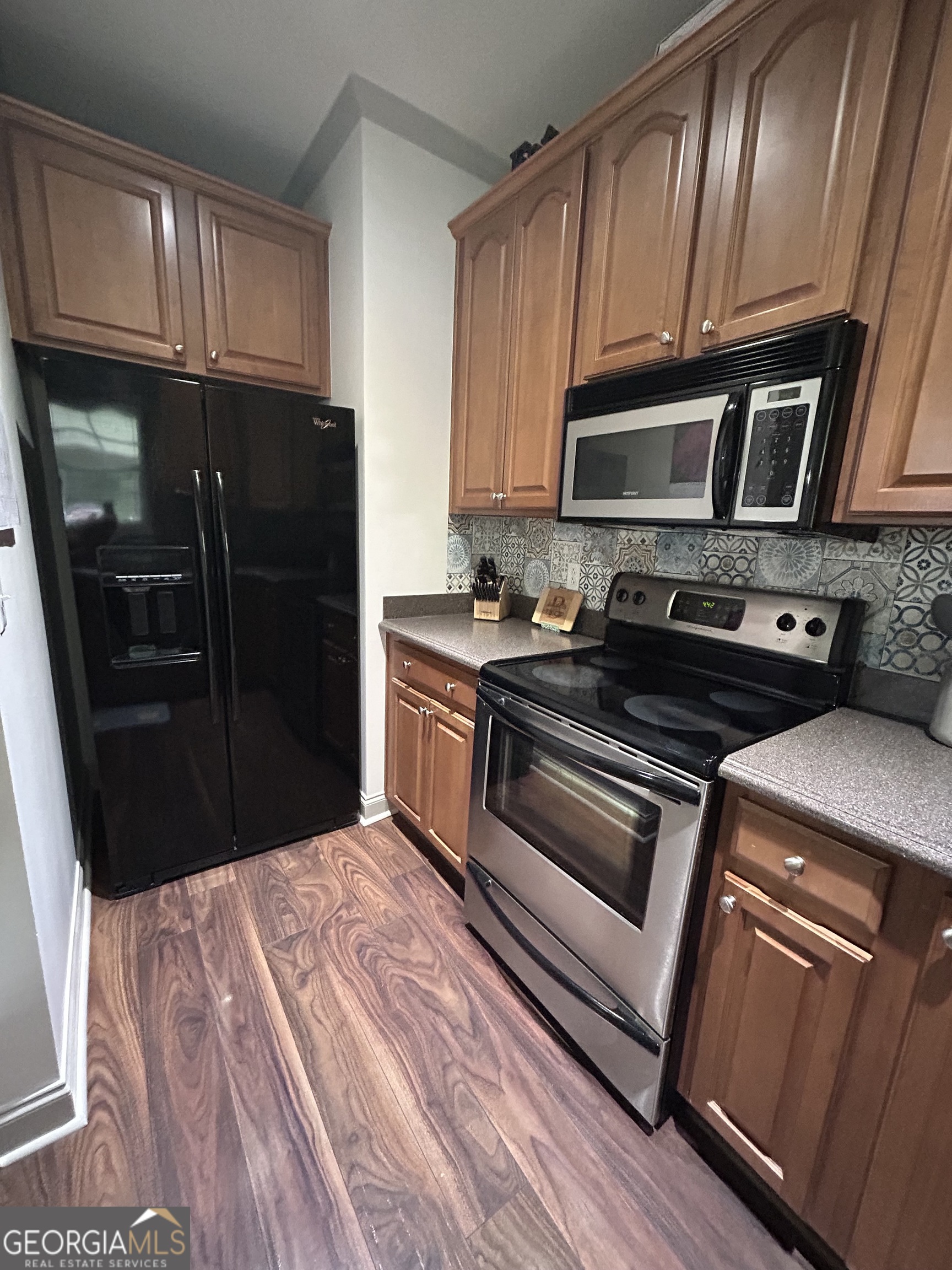 94 24th Avenue Eastman, GA 31023 - Photo 15 of 27 a kitchen with granite countertop wooden cabinets and stainless steel appliances