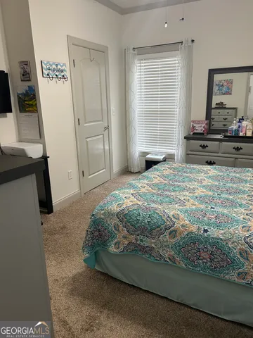 a bedroom with a bed and a flat tv screen on the dresser