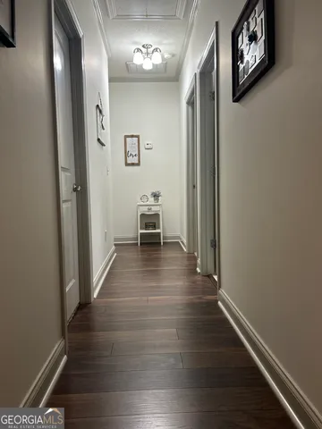 a view of a hallway with wooden floor and a window