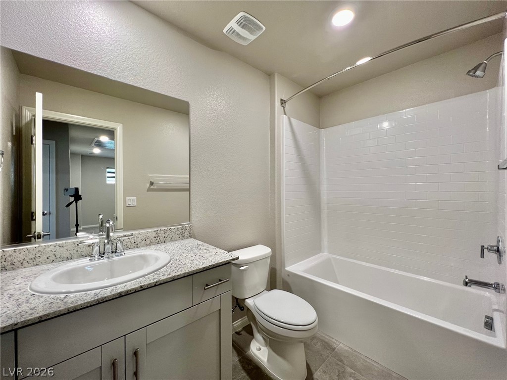 7845 Morganite Avenue Las Vegas, NV 89113 - Photo 19 of 21 A well-appointed bath boasts a sleek vanity with ample counter space and a classic tub-shower combination.
