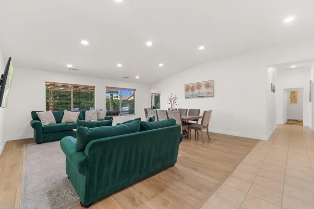 a view of a hallway with wooden floor and a bathroom