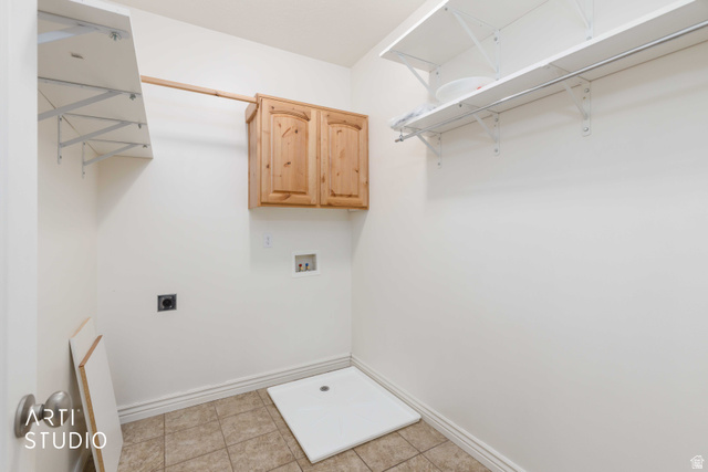 2327 Bluff Ridge Drive Syracuse, UT 84075 - Photo 18 of 66 Utility room featuring built-in shelving, wall-mounted cabinetry, tile flooring, and appliance hookups