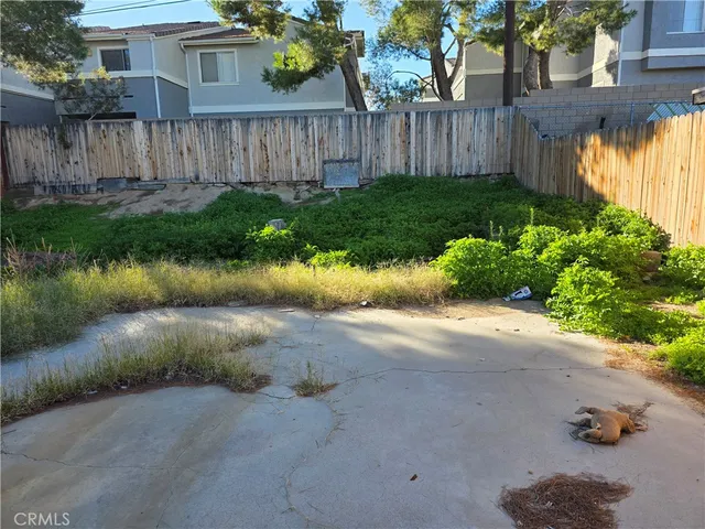 a view of a backyard with wooden fence
