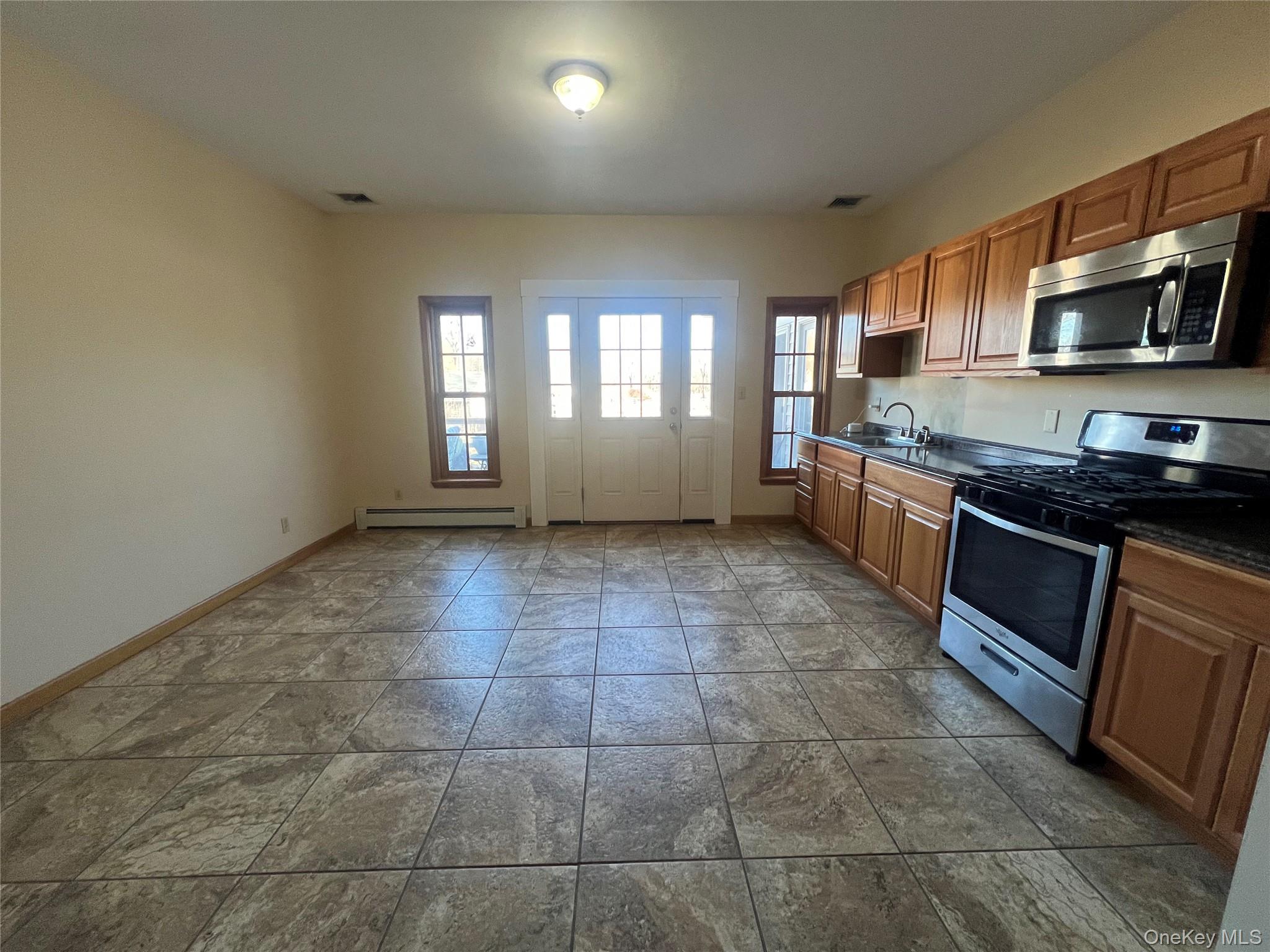 a kitchen with stainless steel appliances a stove a sink a microwave a counter top space and cabinets