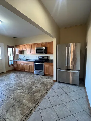 a kitchen with stainless steel appliances granite countertop a refrigerator and a stove top oven