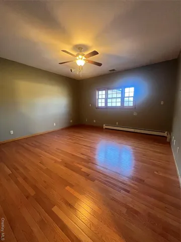 an empty room with wooden floor chandelier and glass door