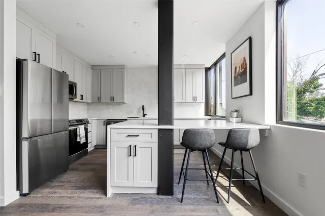 a kitchen with stainless steel appliances granite countertop a sink refrigerator and cabinets