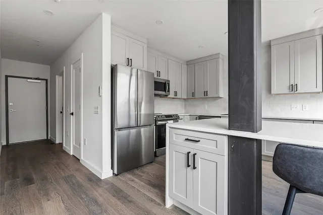 a kitchen with white cabinets and stainless steel appliances
