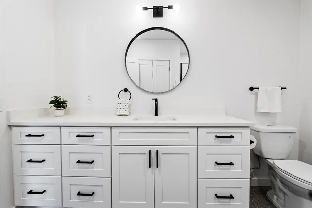 a bathroom with a toilet a sink and mirror