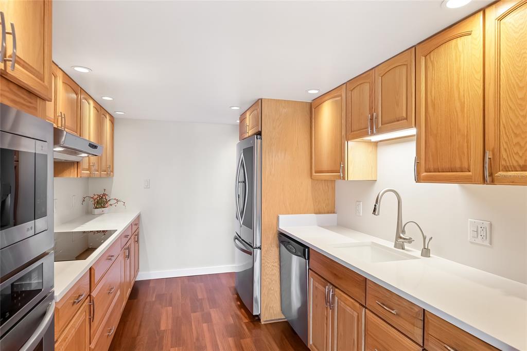 435 South Gulfstream Avenue, Unit 1004 Sarasota, FL 34236 - Photo 11 of 37 a kitchen with a sink a counter top space and cabinets