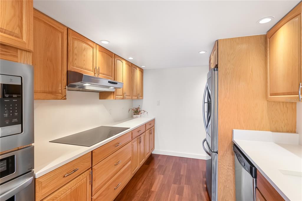 435 South Gulfstream Avenue, Unit 1004 Sarasota, FL 34236 - Photo 12 of 37 a kitchen with a sink a refrigerator and cabinets