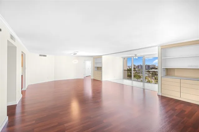 a view of a big room with wooden floor and windows