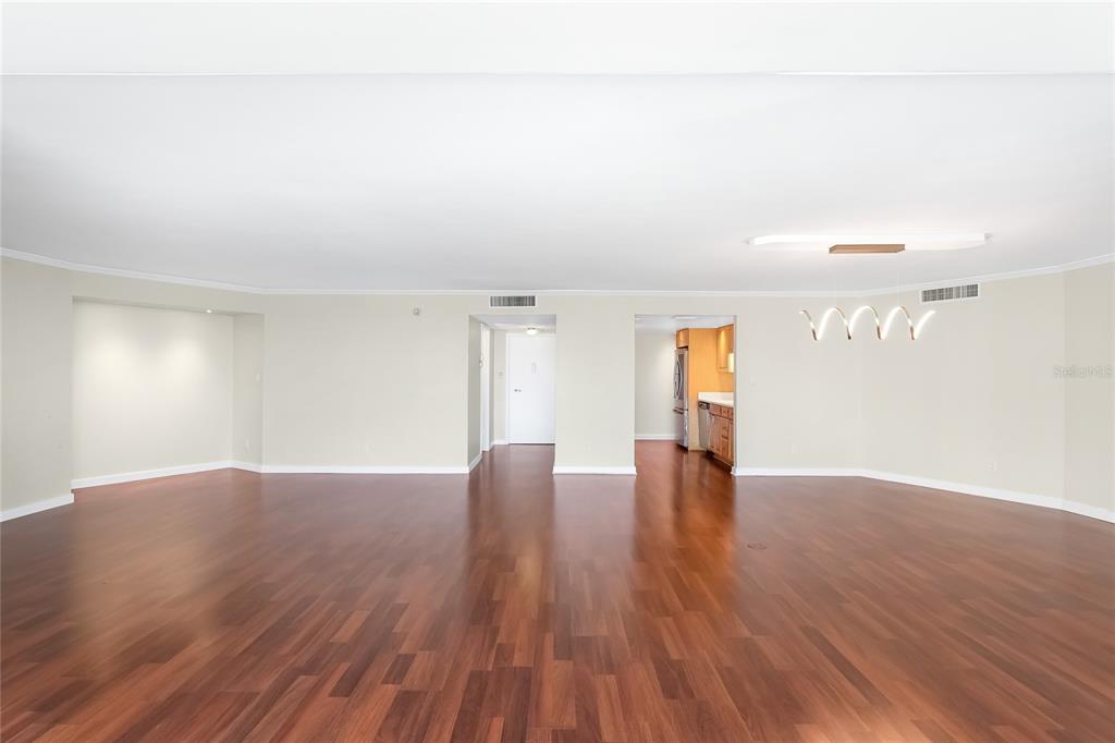 435 South Gulfstream Avenue, Unit 1004 Sarasota, FL 34236 - Photo 8 of 37 a view of an empty room with wooden floor and a window