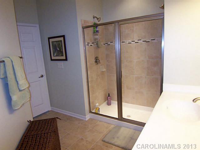 113 Inlet Point Drive, Unit 78 Tega Cay, SC 29708 - Photo 11 of 16 a bathroom with a glass shower door