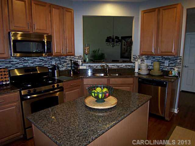 113 Inlet Point Drive, Unit 78 Tega Cay, SC 29708 - Photo 5 of 16 a kitchen with a sink a stove and a microwave