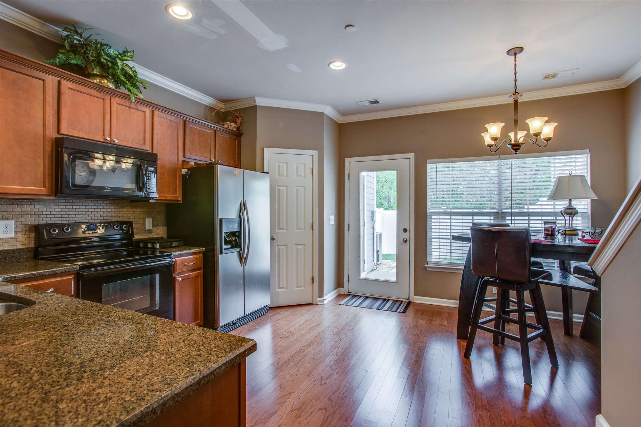 2015 Hemlock Drive Spring Hill, TN 37174 - Photo 9 of 22 a kitchen with stainless steel appliances granite countertop a refrigerator a stove a kitchen island a dining table and chairs with wooden floor