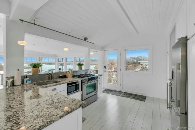 a kitchen with stainless steel appliances granite countertop a lot of counter space and wooden floors