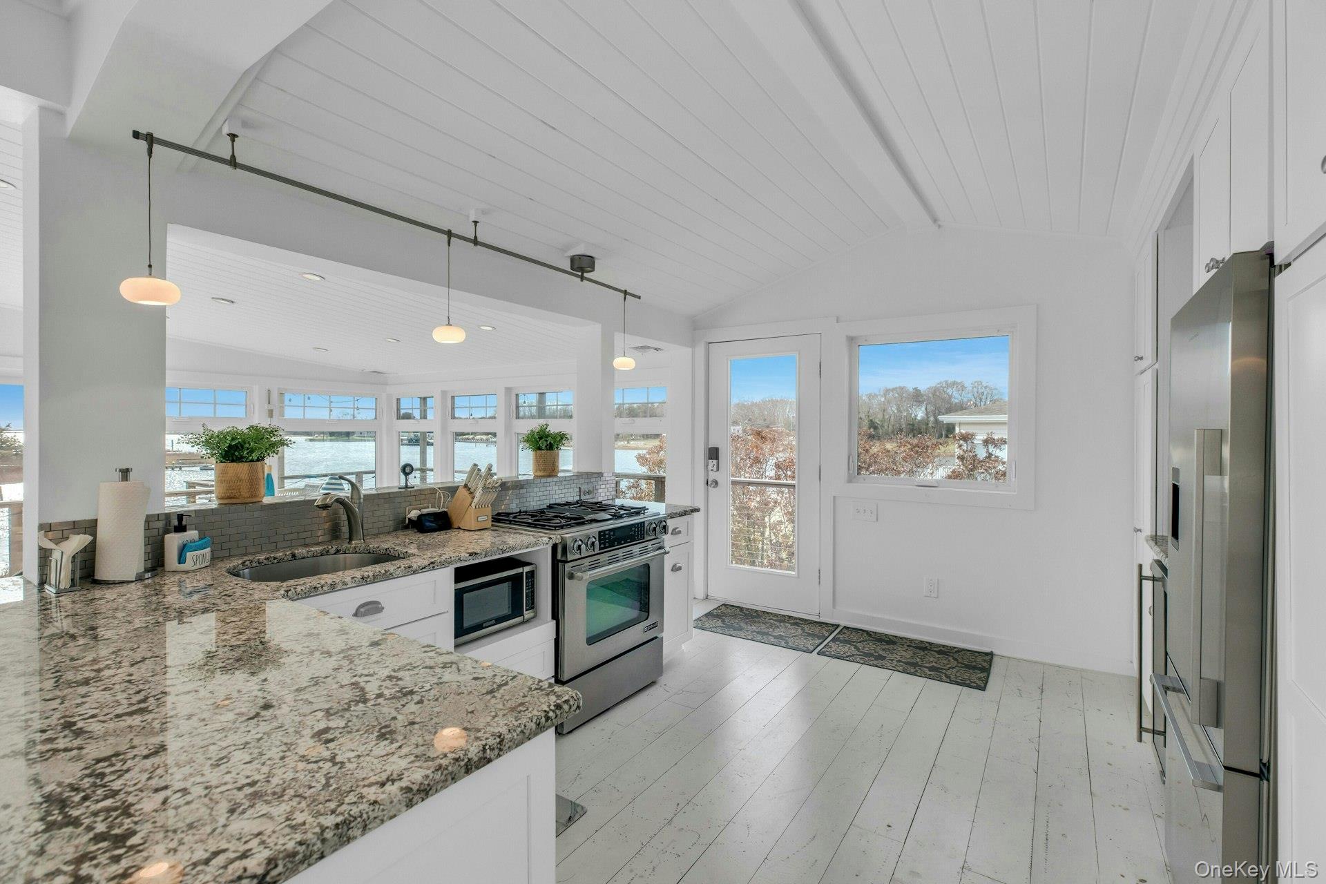 7 Springville Circle Hampton Bays, NY 11946 - Photo 11 of 43 Kitchen with light stone countertops, white cabinetry, hanging light fixtures, appliances with stainless steel finishes, and wood ceiling