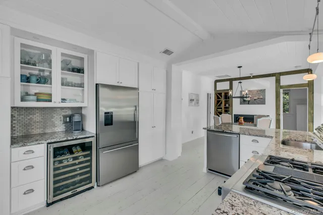 a kitchen with stainless steel appliances granite countertop a refrigerator and a stove top oven