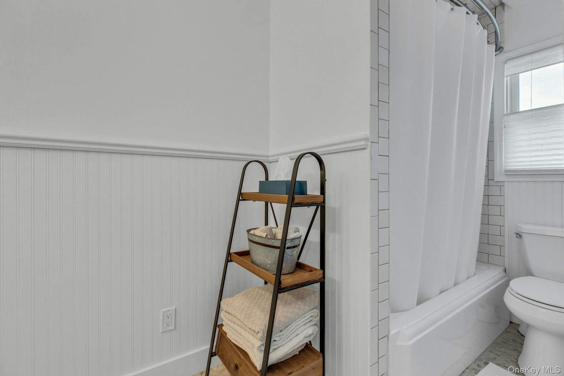 7 Springville Circle Hampton Bays, NY 11946 - Photo 19 of 43 Bathroom featuring a wainscoted wall and shower / bathtub combination with curtain