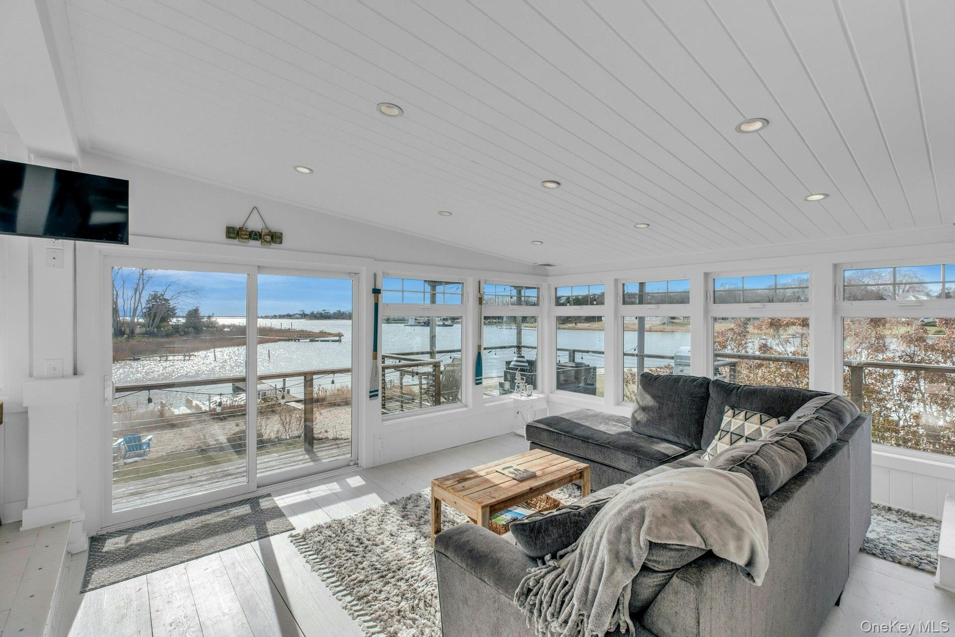 7 Springville Circle Hampton Bays, NY 11946 - Photo 6 of 43 Sunroom / solarium featuring lofted ceiling, a water view, recessed lighting, wood-type flooring, and wood ceiling