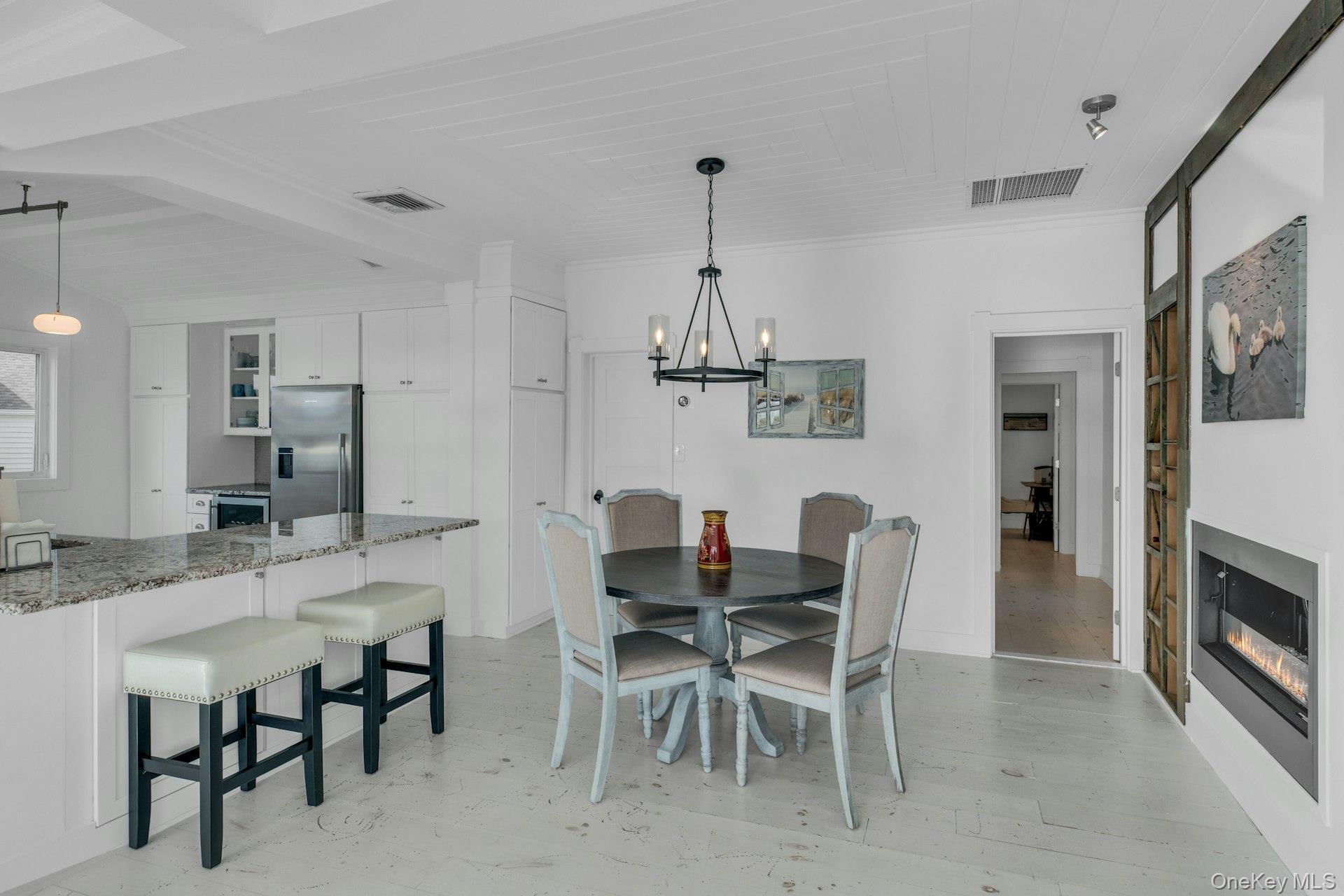 7 Springville Circle Hampton Bays, NY 11946 - Photo 9 of 43 Dining space with a glass covered fireplace and a chandelier
